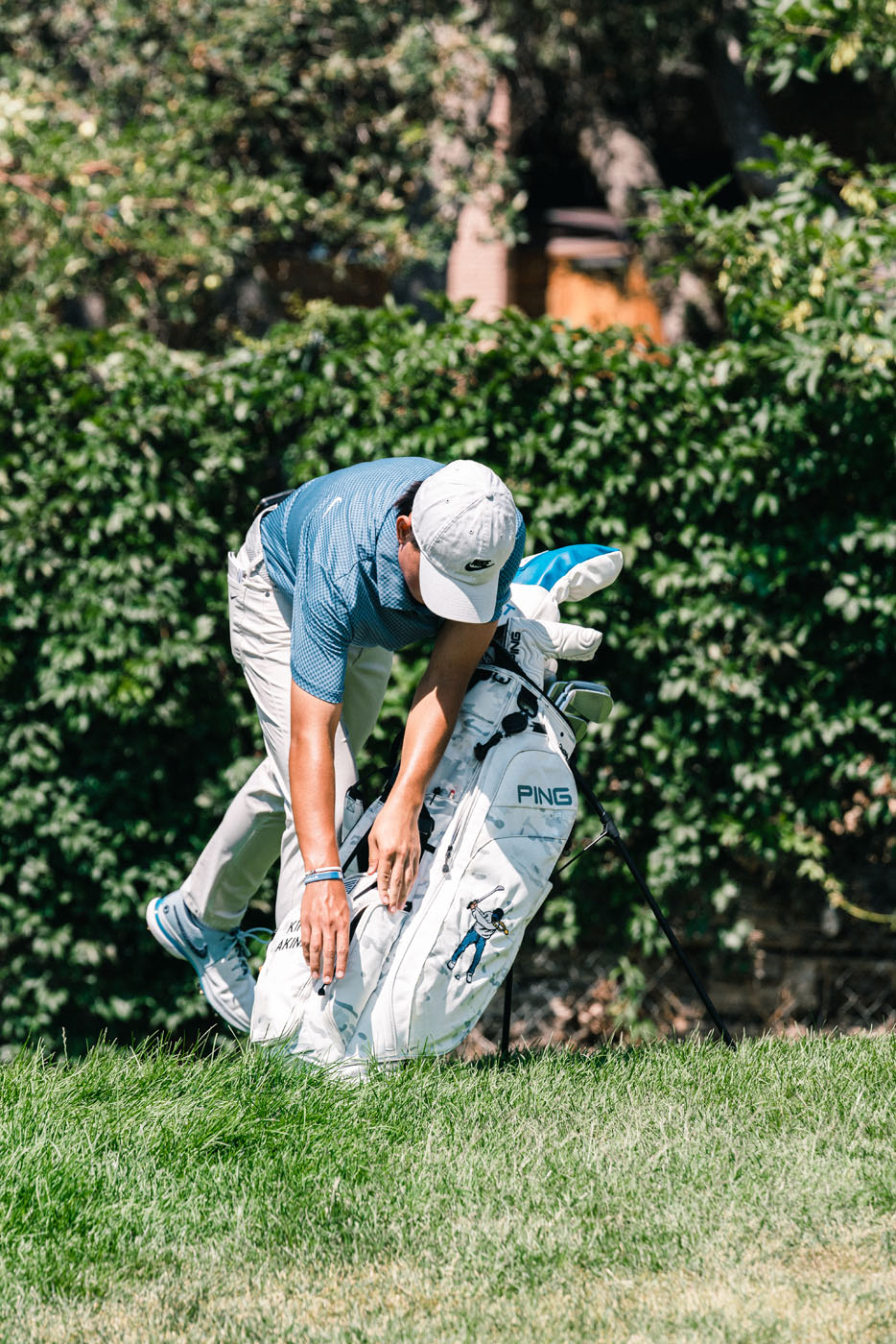 An image of a golfer bending over their custom golf bag - for fitted golf clubs, contact Tee Box.