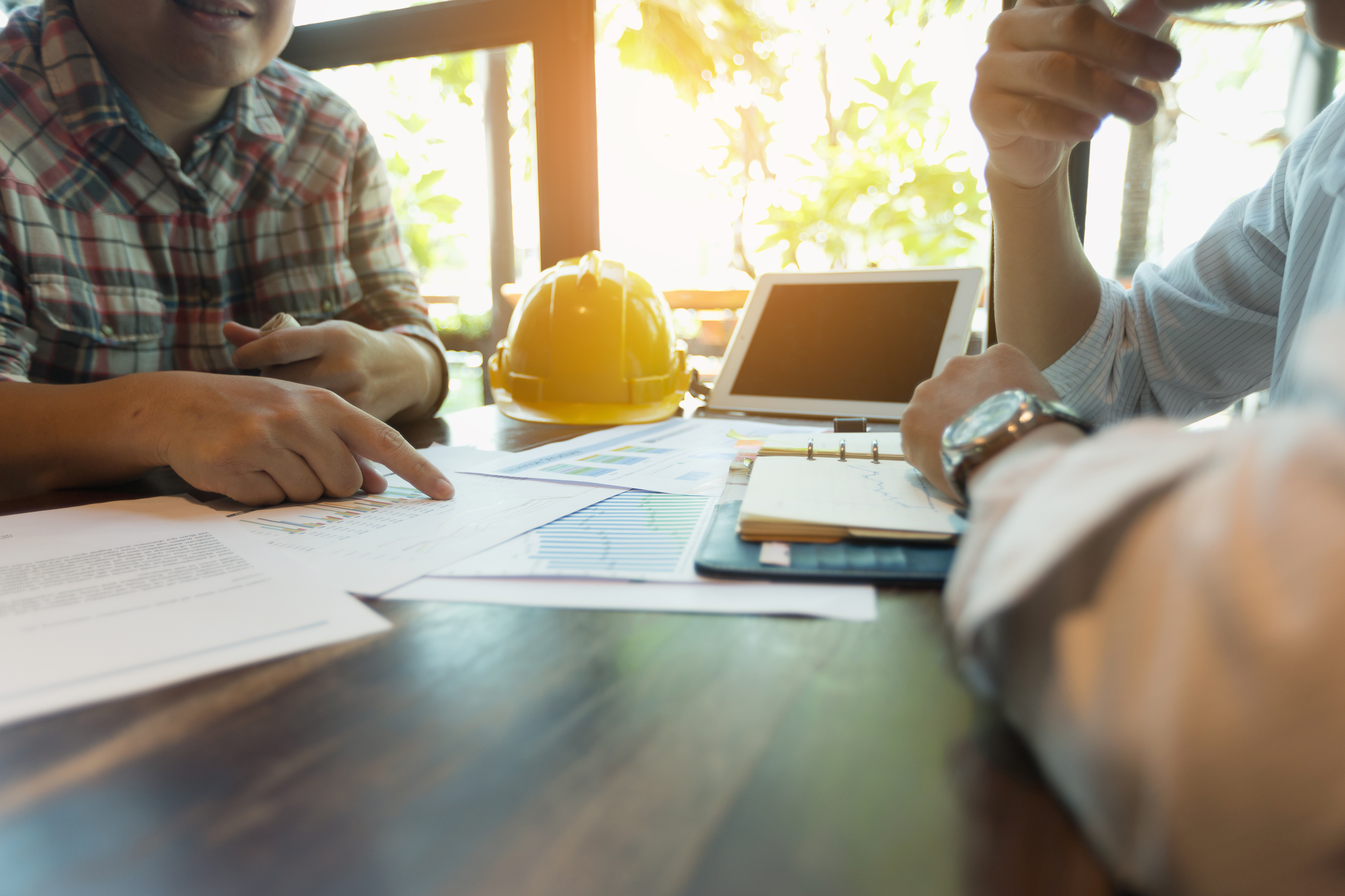 Two successful franchise owners at Anchored Tiny Homes look over plans for an ADU project.