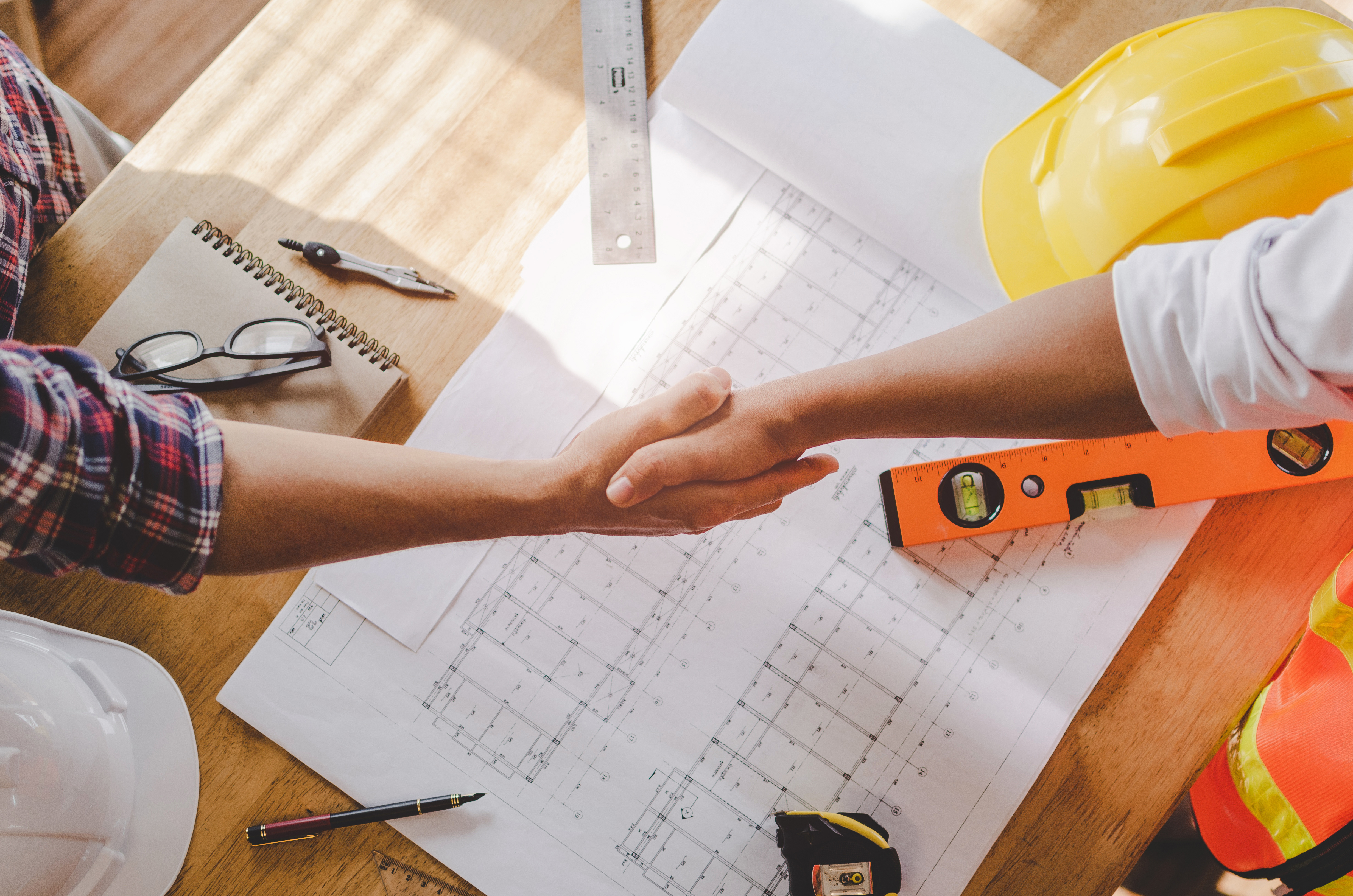 A pair of Anchored Tiny Homes Franchise Owners look over plans for an ADU project and onwership expenses.