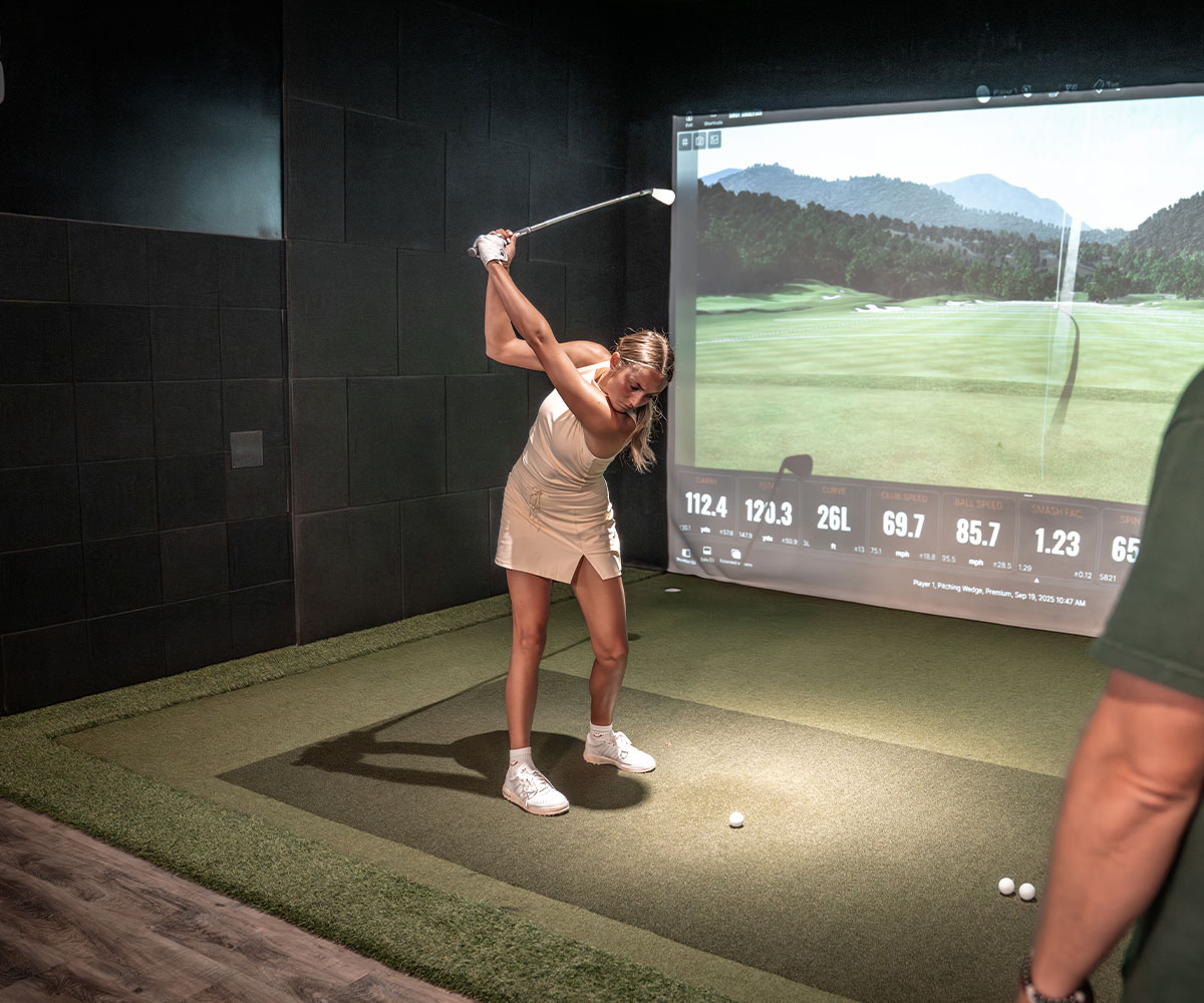 A woman meeting with a Tee Box coach for ladies golf lessons.