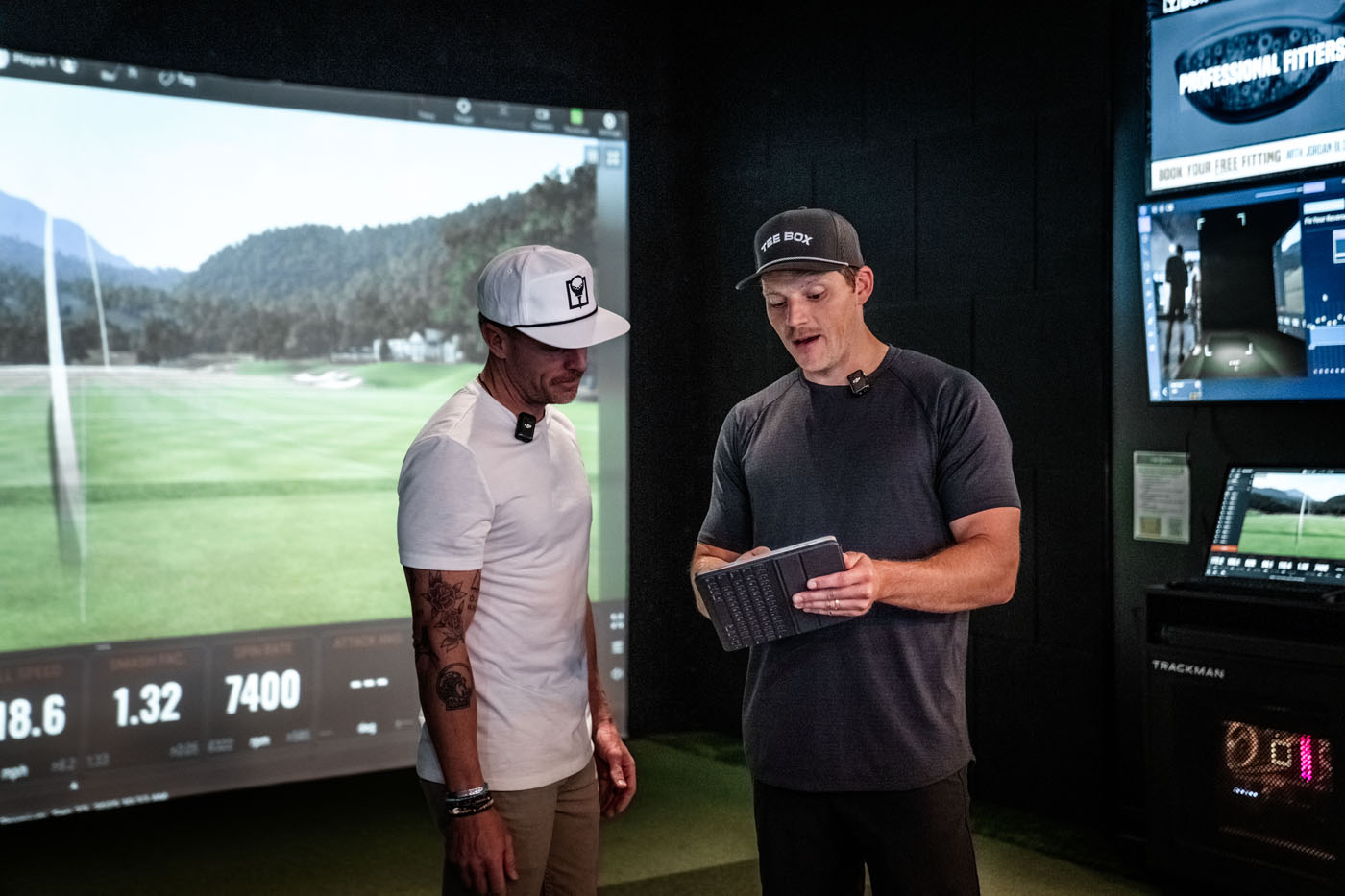 A Tee Box pro reviewing performance data with a golfer - our golf lesson prices support a complete development plan, not just a single lesson.