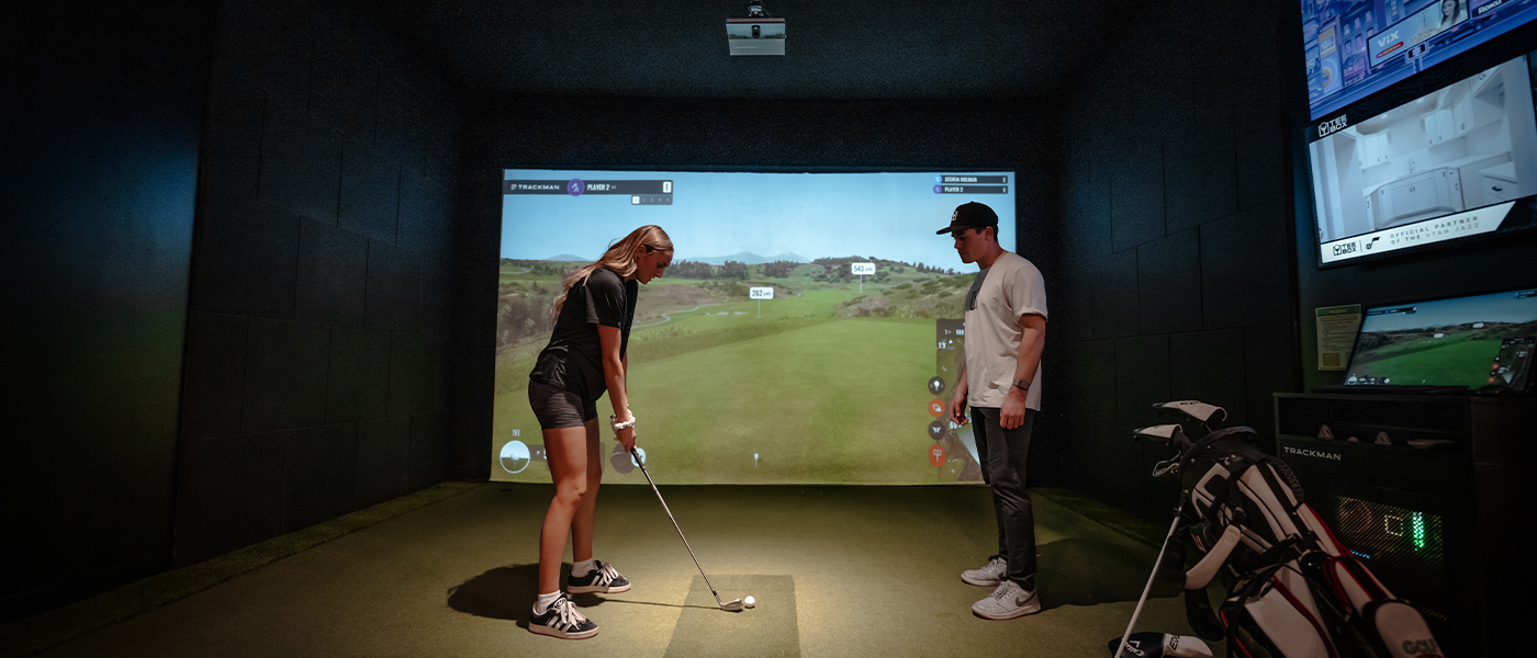 A woman meeting with a Tee Box coach for ladies golf lessons.
