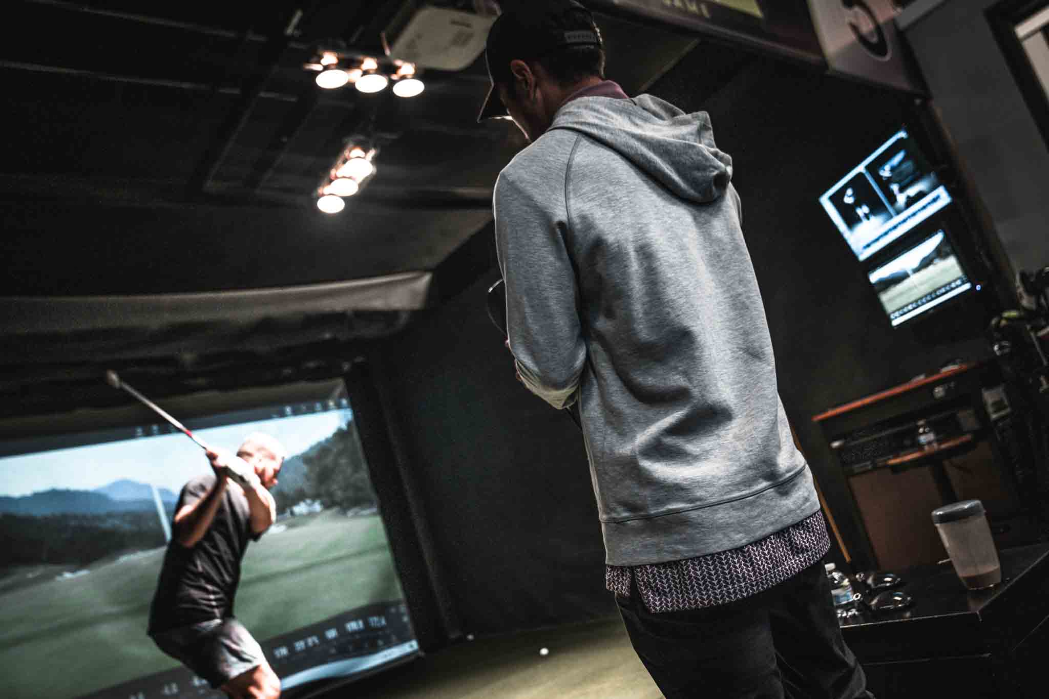 Two golfers in the Tee Box golf community using the sim bays.