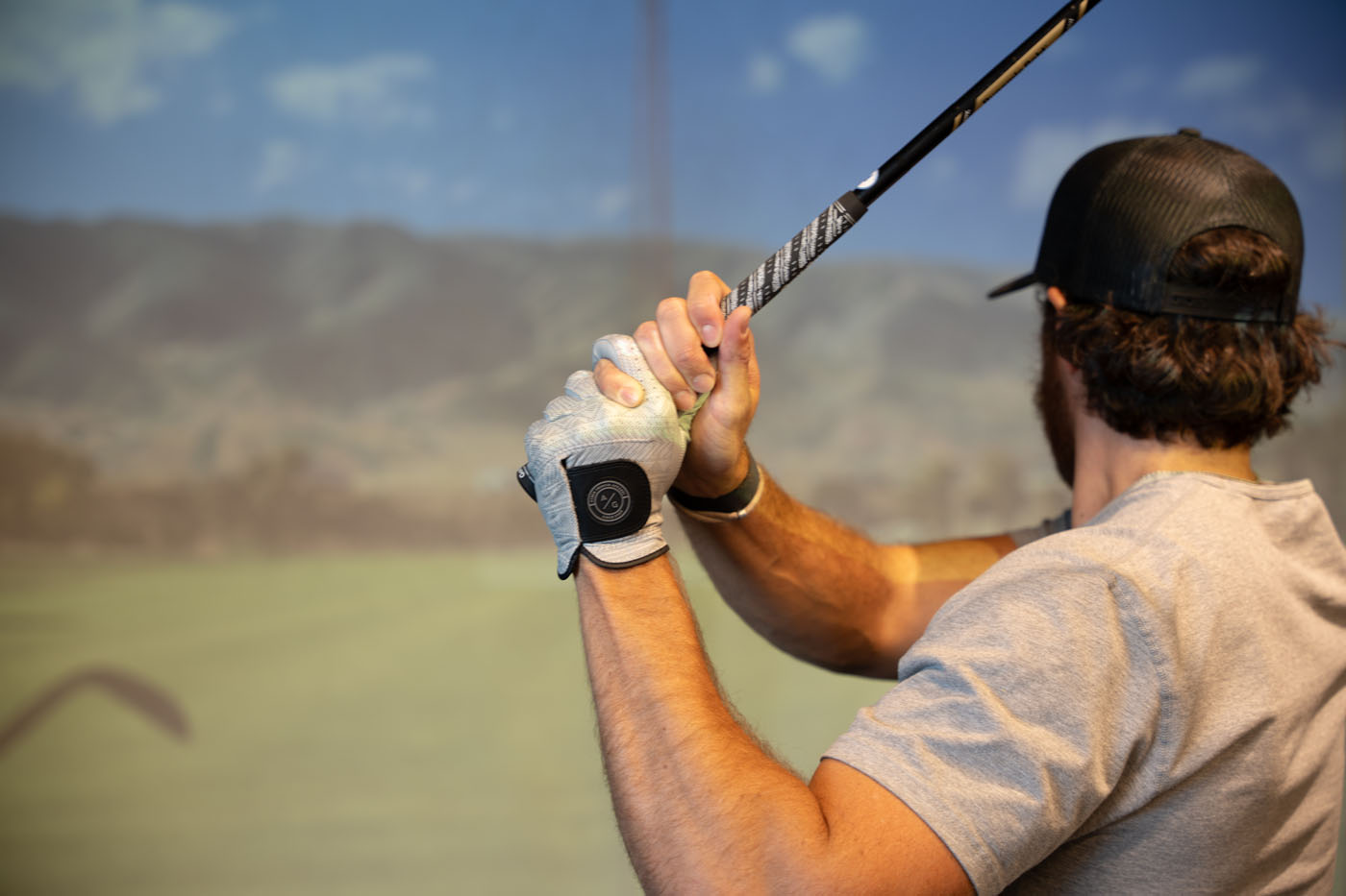 A golfer mid-swing at Tee Box.