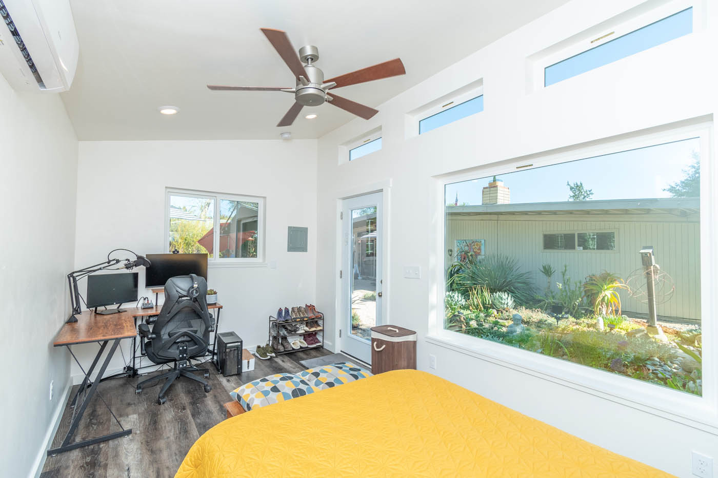 A beautiful office space with a yellow bed - built by Anchored Tiny Homes.