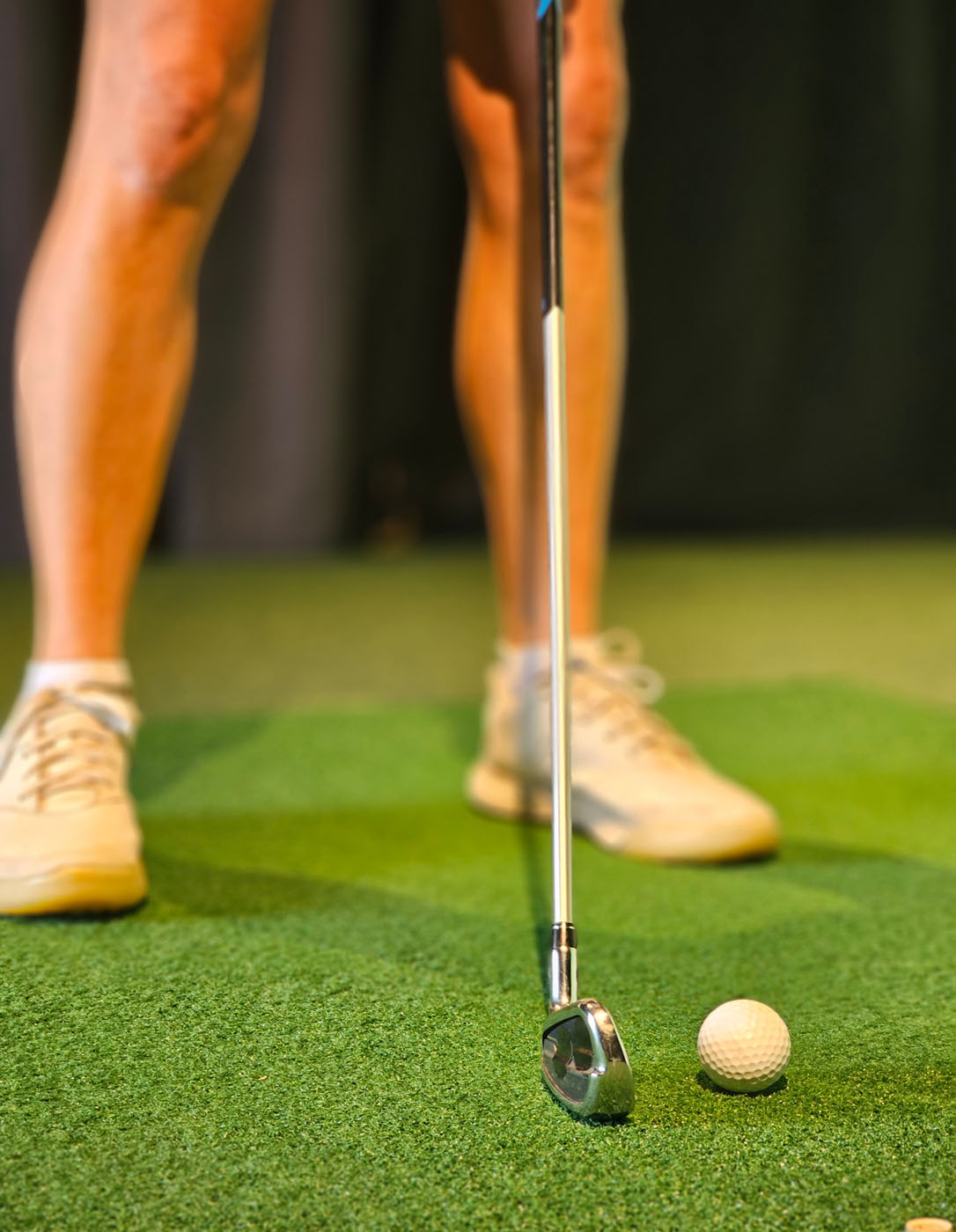 An image of a golf ball and club lined up for a hit at Tee Box.