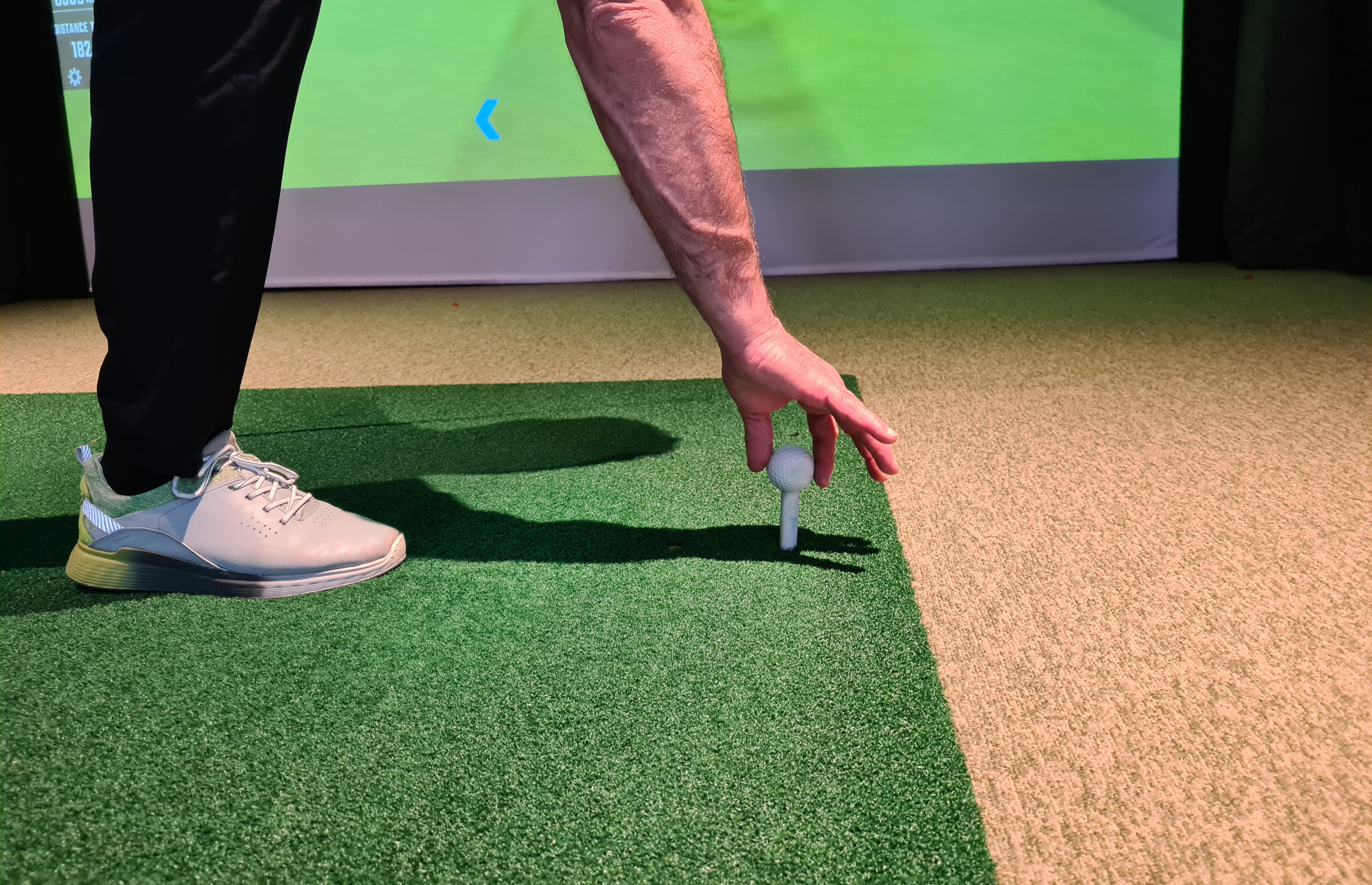A close up of a golfer using a Trackman golf simulator at Tee Box - learn more about golf simulator accuracy with our expert team! 