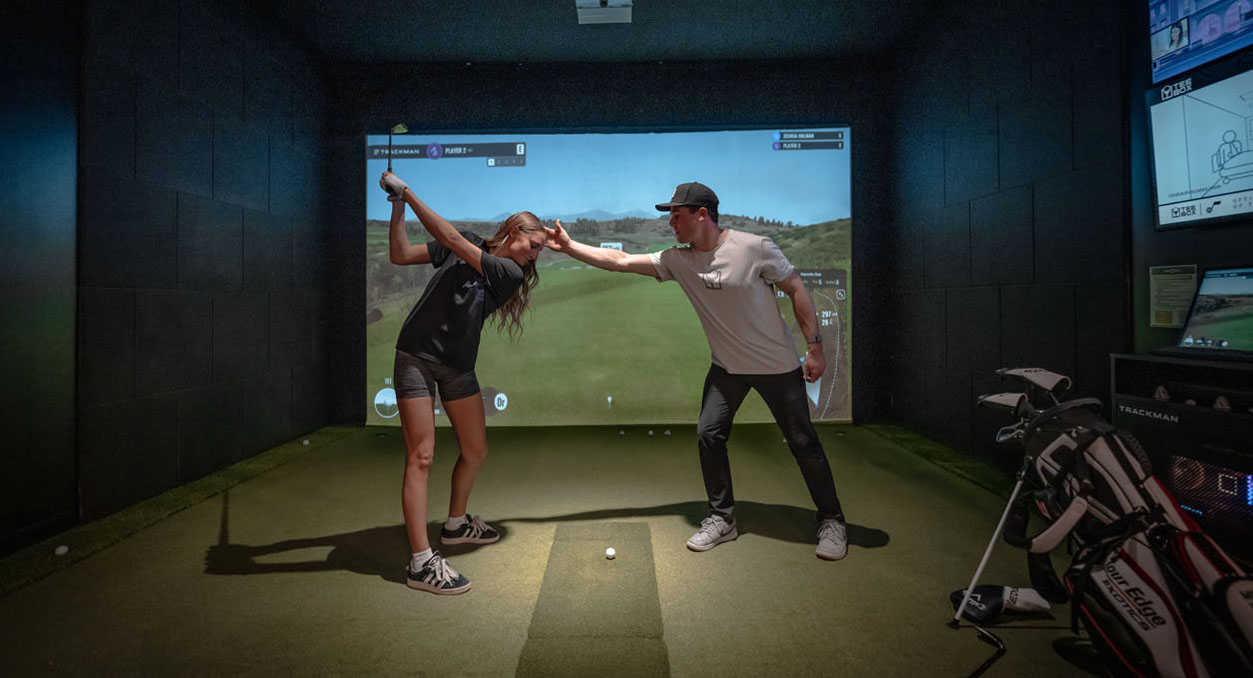 A golfer and Box Pro at Tee Box using our indoor screen golf.