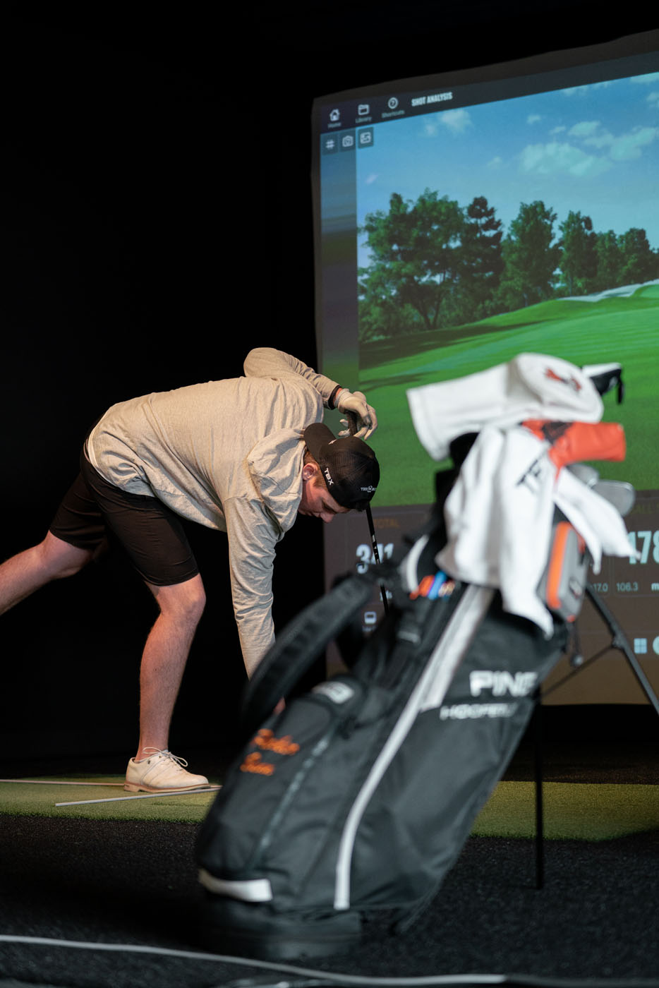 A golfer using our simulators with their golf bag.