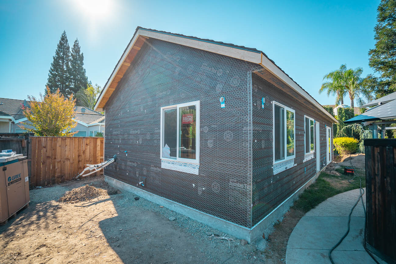 A detached ADU in a California backyard by a pool, learn more about our best ADU contractors.